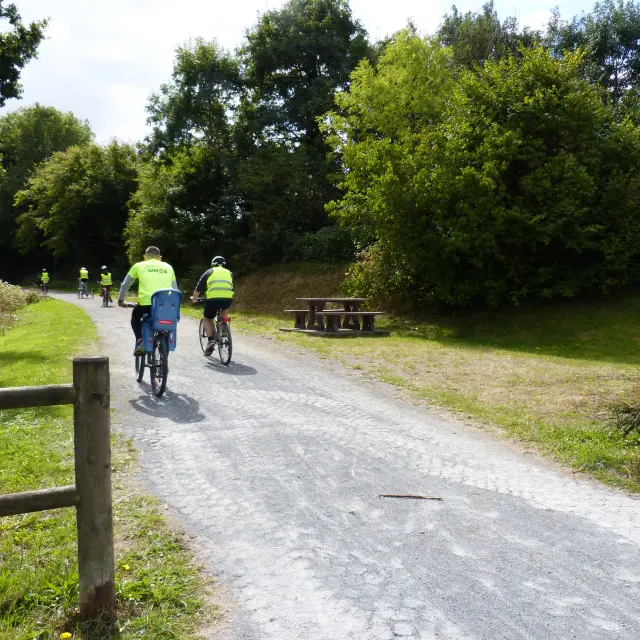 Deux cyclistes en jaune et bleu roulent sur la voie verte
