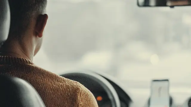 Conducteur portant des écouteurs, vue depuis le siège passager