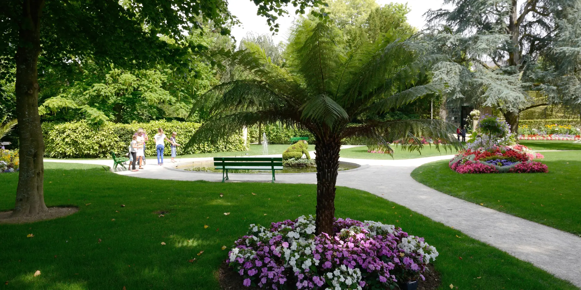 Jardin des plantes de Coutances avec des fleurs, des arbres et des chemins de promenade