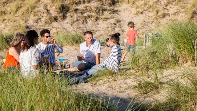 Un groupe de personnes pique-niquant sur une plage de sable