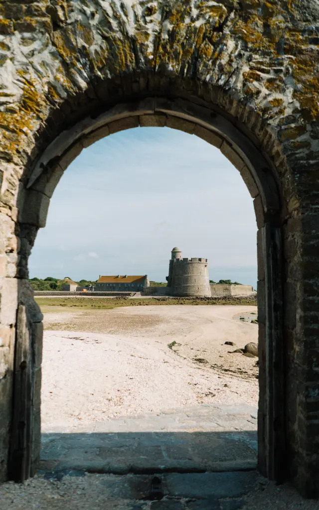 Vue à travers une arche de pierre sur l'île de Tatihou