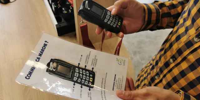 Une personne tient un audio-guide et une notice d'utilisation