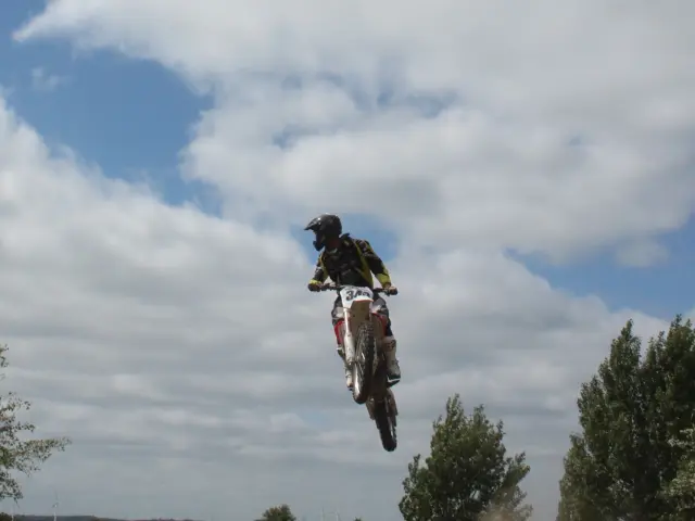 Un motocycliste effectue un saut impressionnant dans le ciel