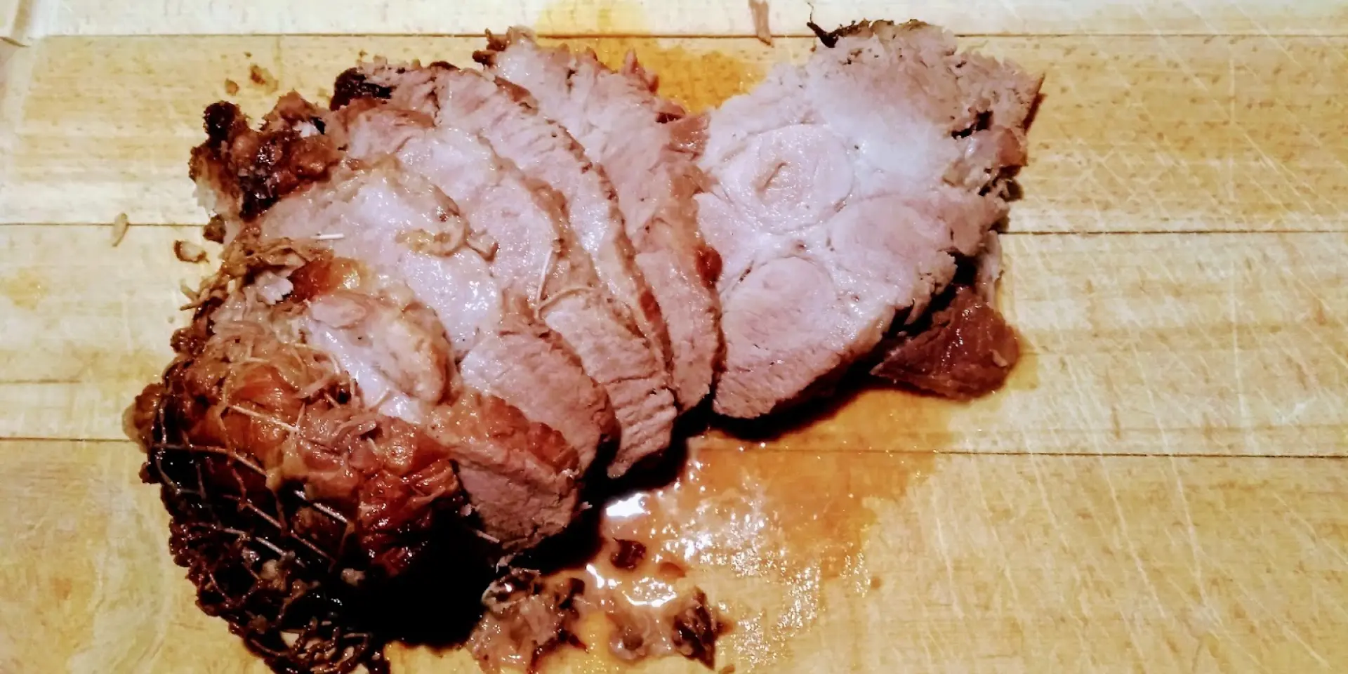 Un rôti de porccoupé en tranches sur une planche à découper en bois