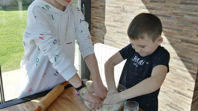 Deux enfants cuisinent ensemble dans une cuisine lumineuse
