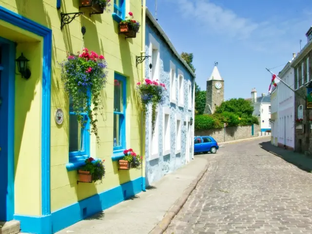 Kopfsteinpflasterstraße mit bunten häusern und hängenden blumen