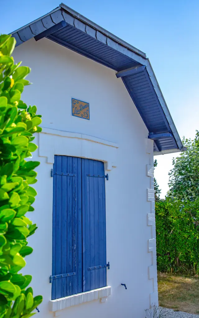 Petite maison blanche avec des volets bleus à Hauteville sur Mer
