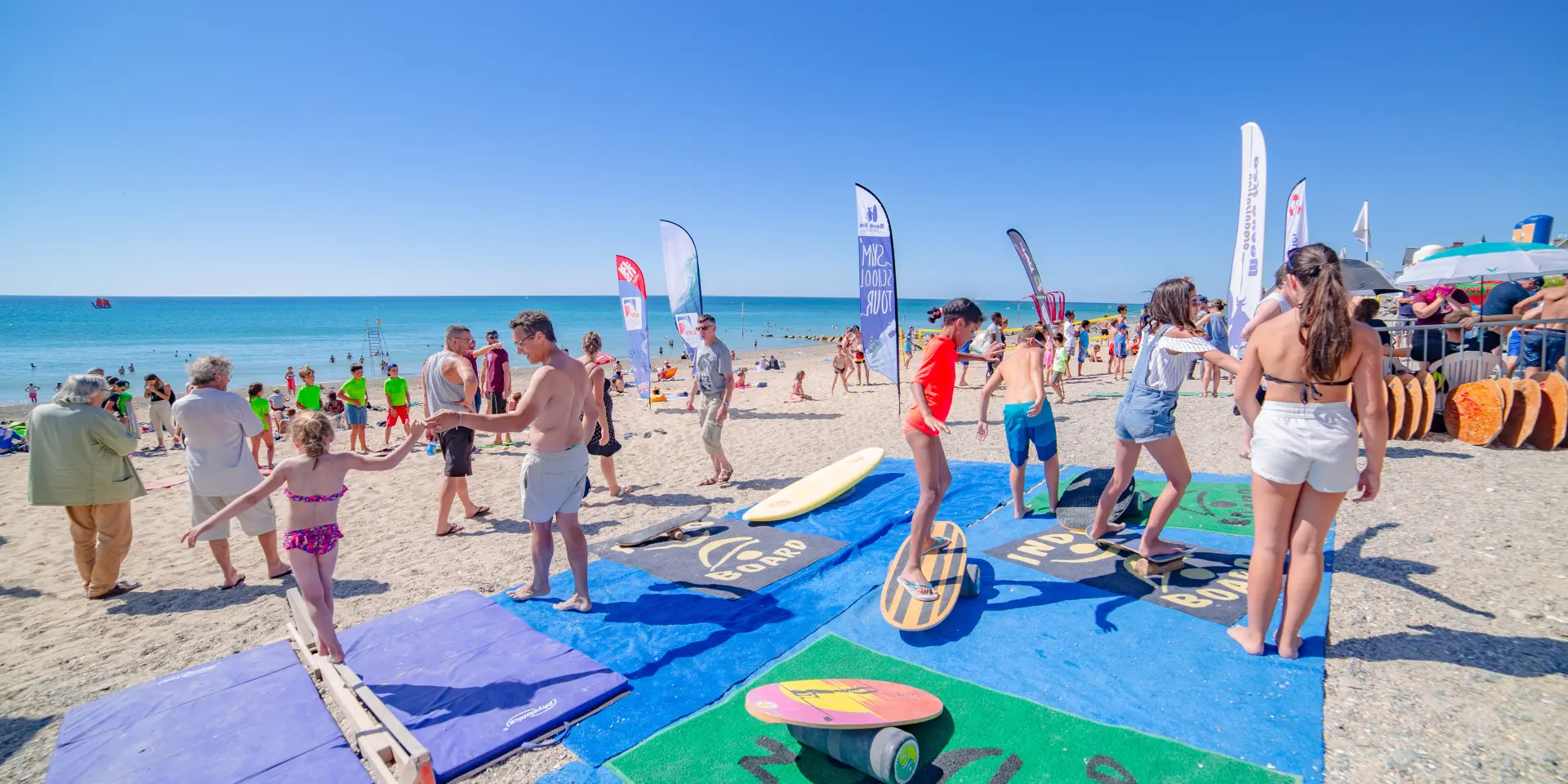 Plage fréquentée avec des parasols colorés et des personnes profitant du soleil