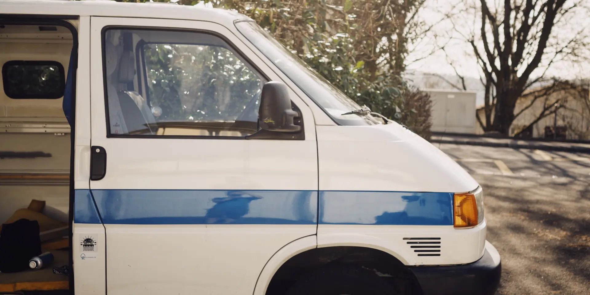 Un van blanc garé dans une forêt ensoleillée