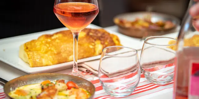 Assiette de brunch avec œufs, bacon, tomates et pain grillé, accompagnée de jus d'orange et de café