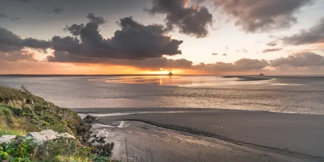 Couchant sur une plage déserte avec le Mont-Saint-Michel