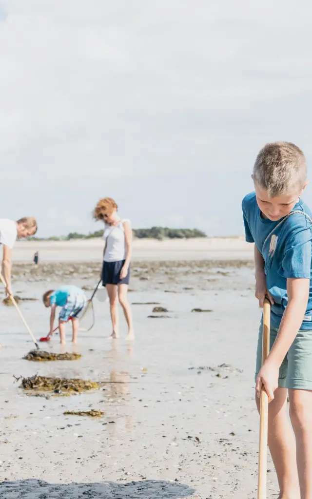 Quatre enfants cherchant des coquillages sur une plage à Agon-Coutainville