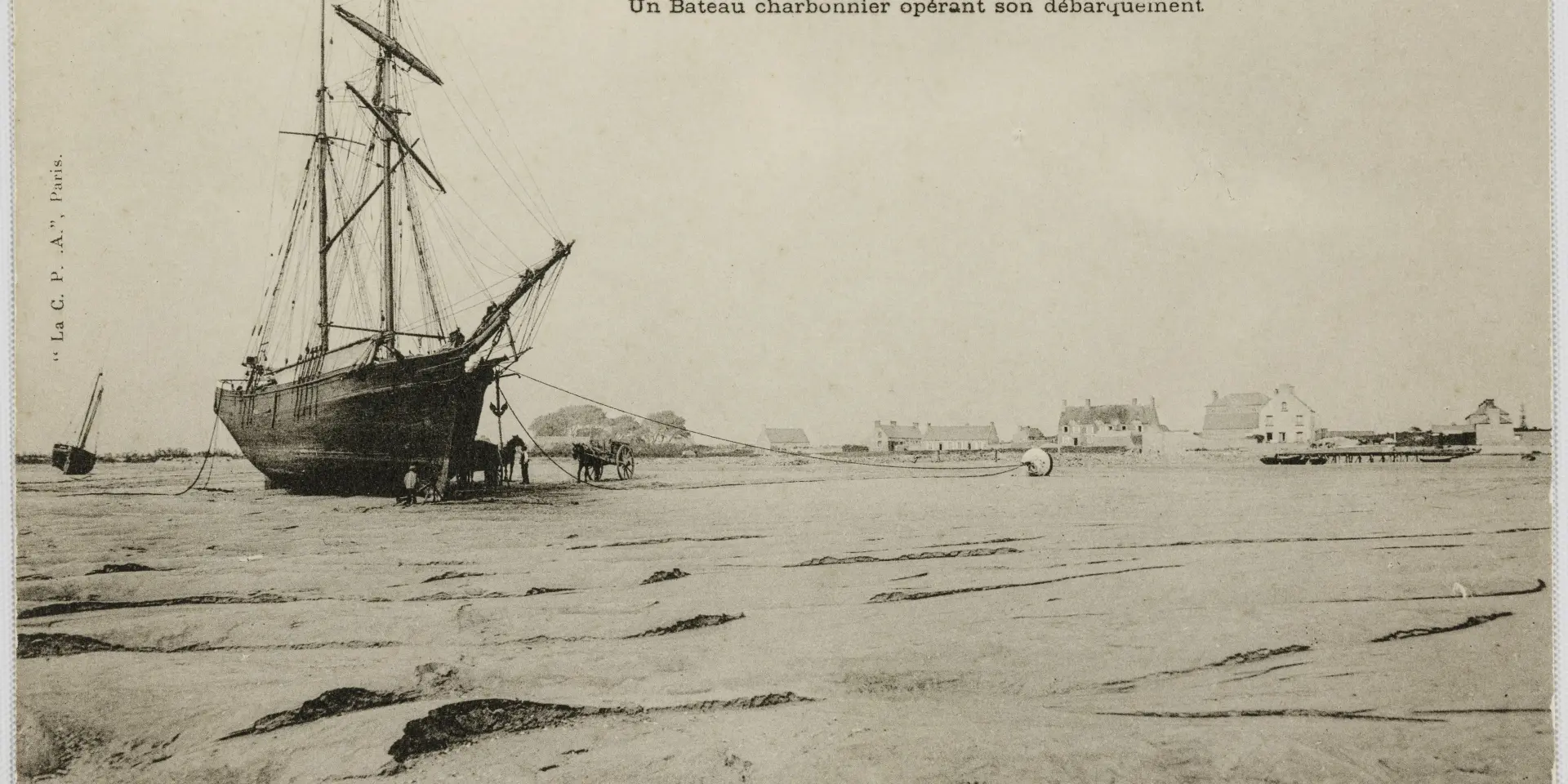 Un bateau charbonnier échoué sur la plage à marée basse
