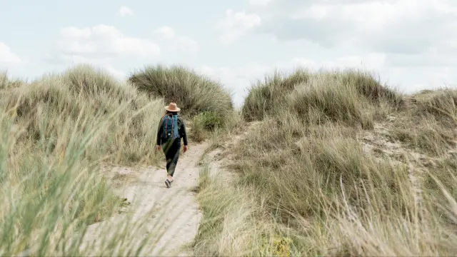 Personne marchant dans un sentier entre les dunes dans le havre de Geffosses
