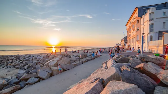 Menschen spazieren auf einer Promenade beim Sonnenuntergang