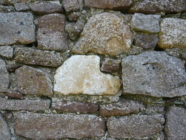 Mur de pierre avec des pierres de différentes tailles et couleurs