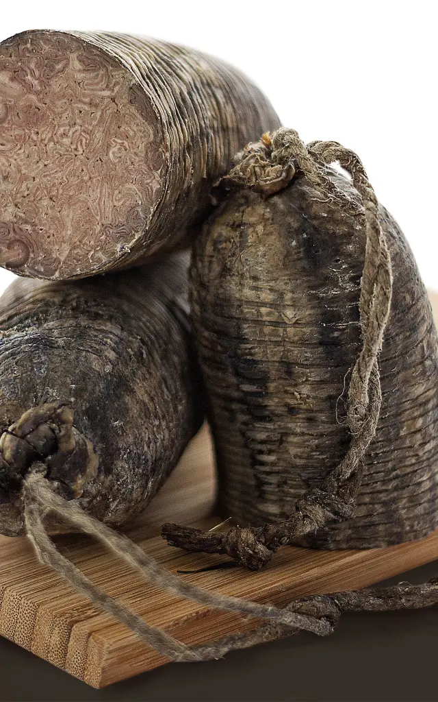 Three artisanal sausages wrapped in burlap