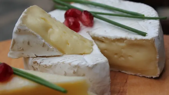 Un plateau de camembert avec des baies et des herbes