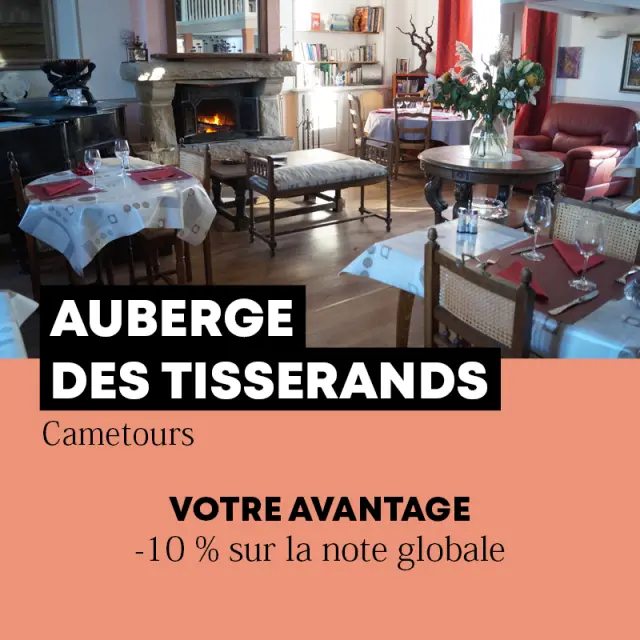 Intérieur d'une auberge avec des tables dressées et une cheminée
