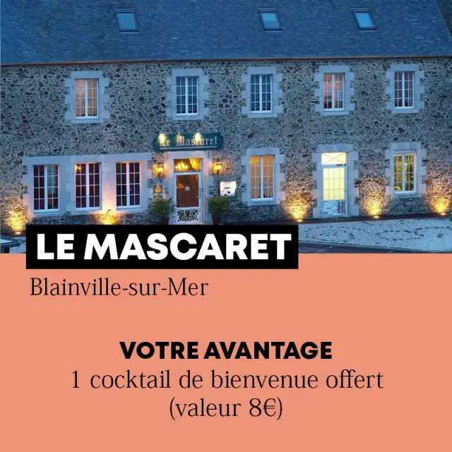 Bâtiment en pierre avec des fenêtres éclairées et une enseigne lumineuse.