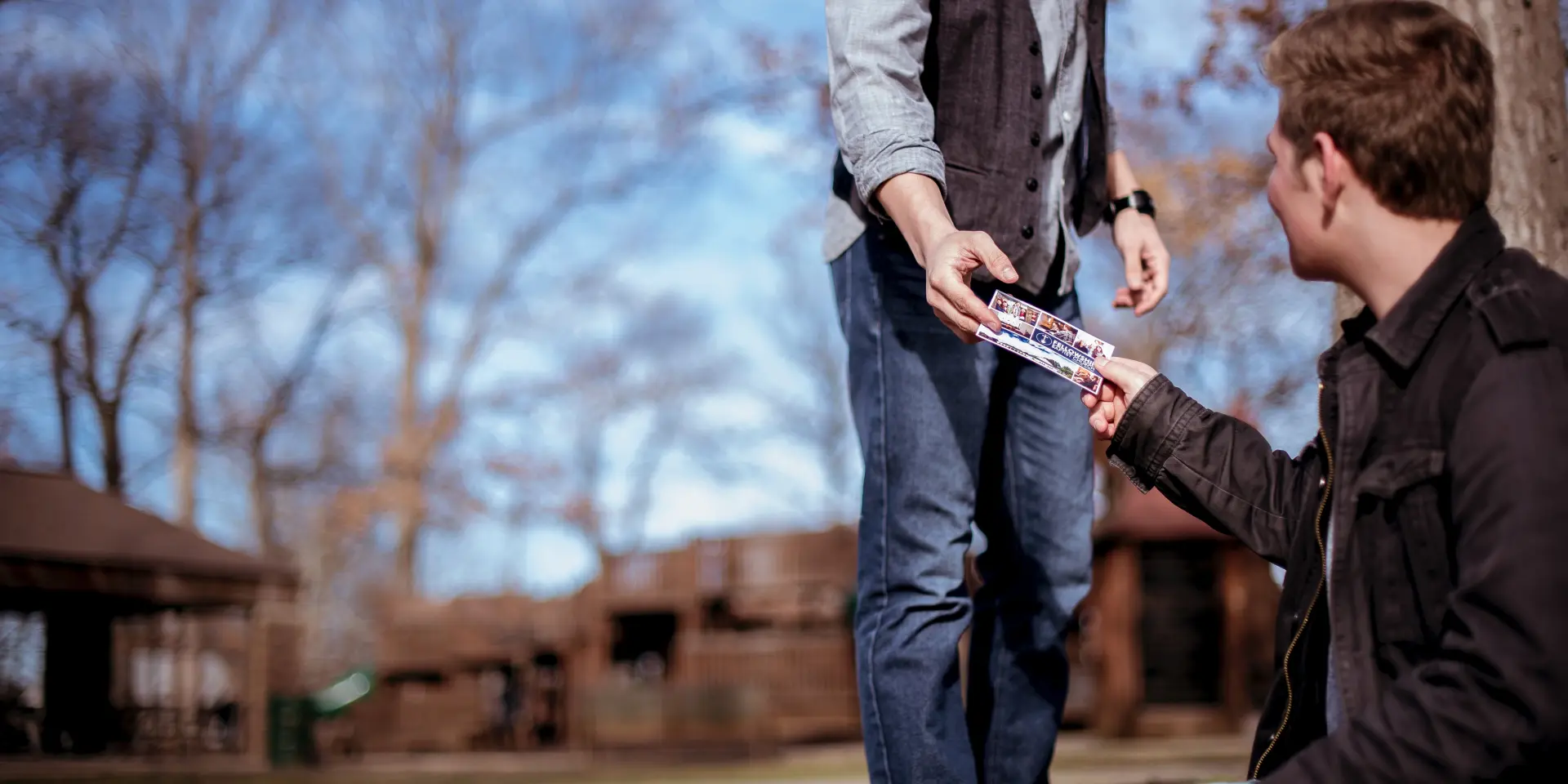 Deux personnes échangent un objet en extérieur