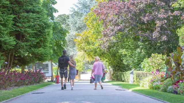Trois personnes marchant sur un chemin au jardin des plantes de Coutances