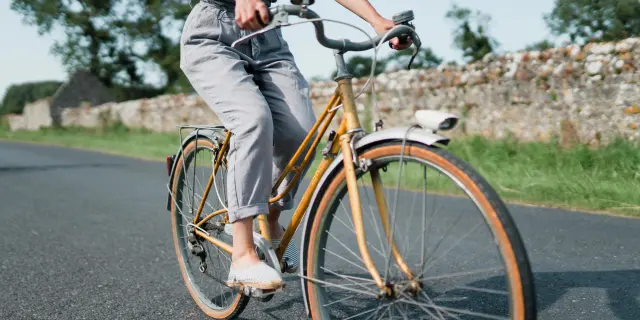 Person riding a vintage bicycle on a country road