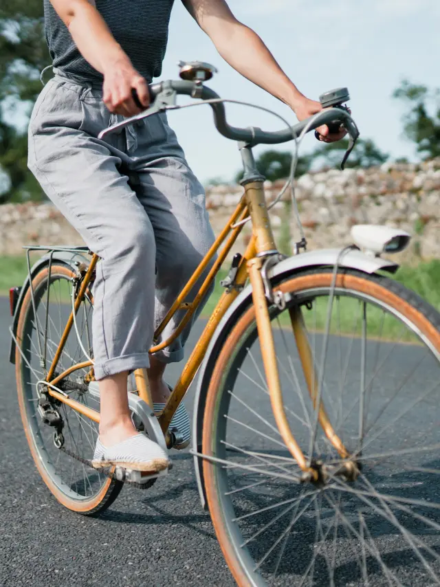 Personne pédalant sur un vélo vintage sur une route de campagne