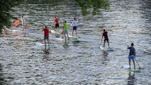Plusieurs personnes faisant du paddle sur une étendue d'eau calme
