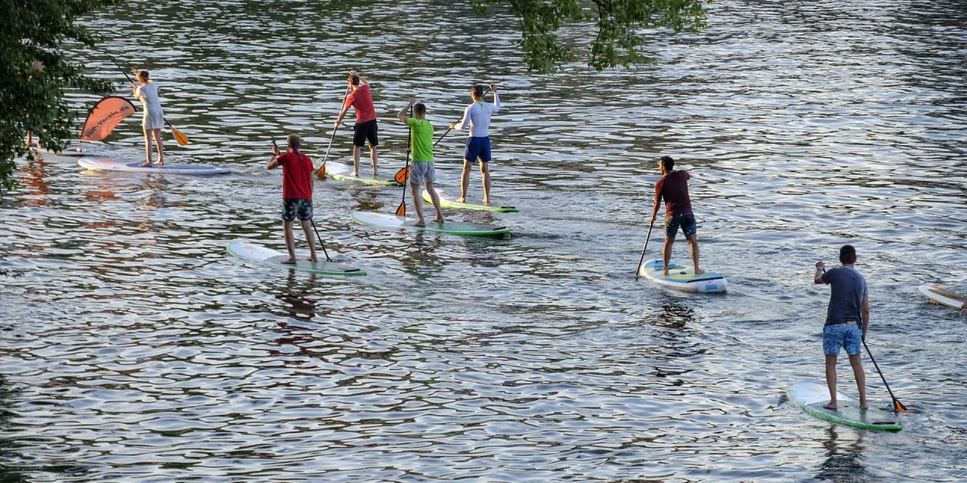 Plusieurs personnes faisant du paddle sur une étendue d'eau calme