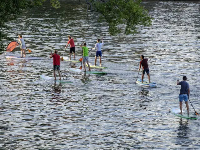 Plusieurs personnes faisant du paddle sur une étendue d'eau calme