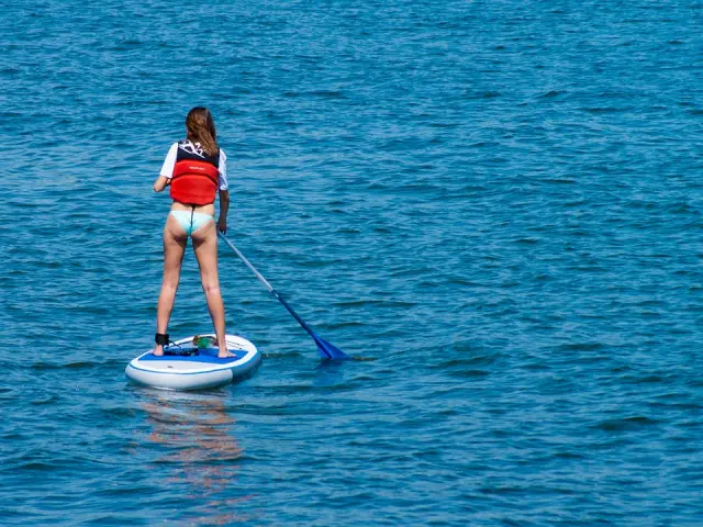 Une personne en paddleboard avec une pagaie dans l'océan