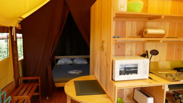 Intérieur d'un chalet avec un lit, une cuisine et une table : lodge aroeven