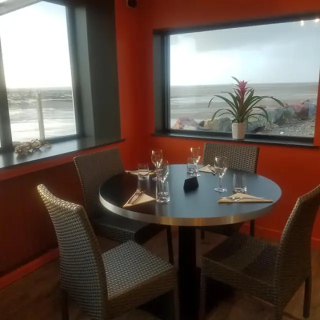 Table ronde avec des verres à vin et une vue sur la mer : Le grand Herbet