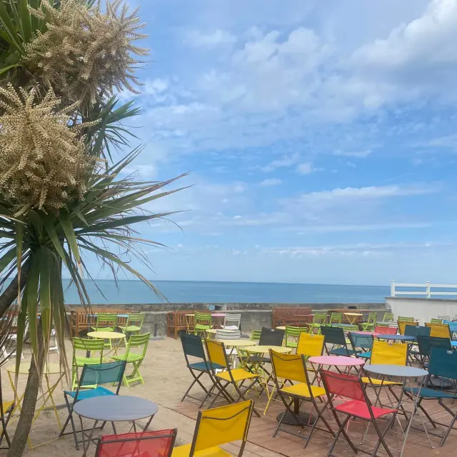 Terrasse avec des chaises colorées face à la mer : La mer Ô vent à Hauteville sur Mer