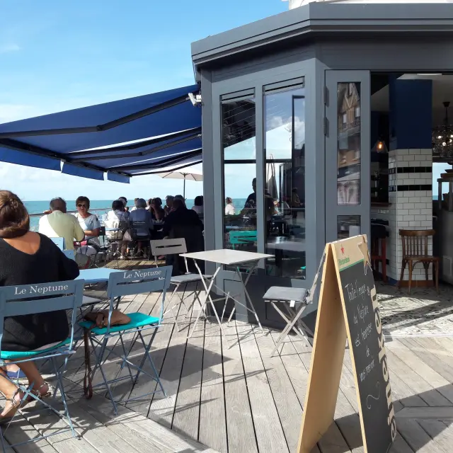 Terrasse du neptune à Agon Coutainville - Un café en bord de mer avec des clients assis à des tables