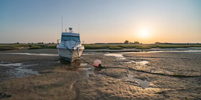 Deux voiliers amarrés sur une plage au coucher du soleil