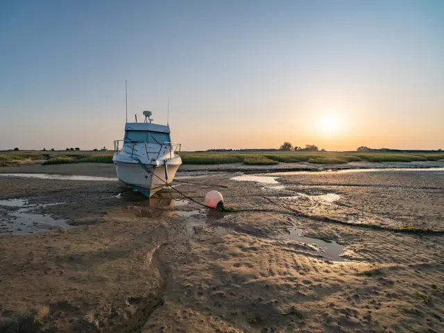 Deux voiliers amarrés sur une plage au coucher du soleil