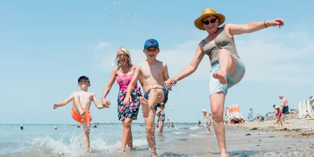 Enfants jouant sur la plage avec une offre de vacances à prix réduits