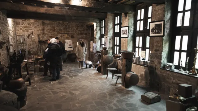 Steinwerkstatt mit Menschen, die antike Instrumente betrachten