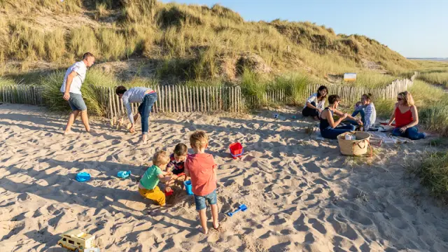 Enfants jouant dans le sable avec des seaux et des pelles