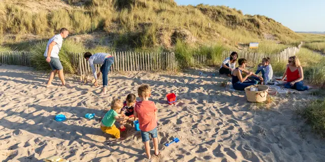 Enfants jouant dans le sable avec des seaux et des pelles