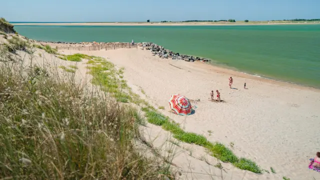 A fine sandy beach with people walking along the coast
