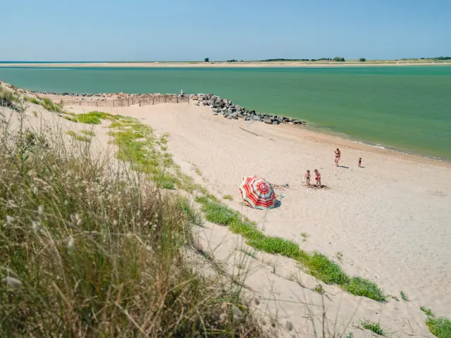 A fine sandy beach with people walking along the coast