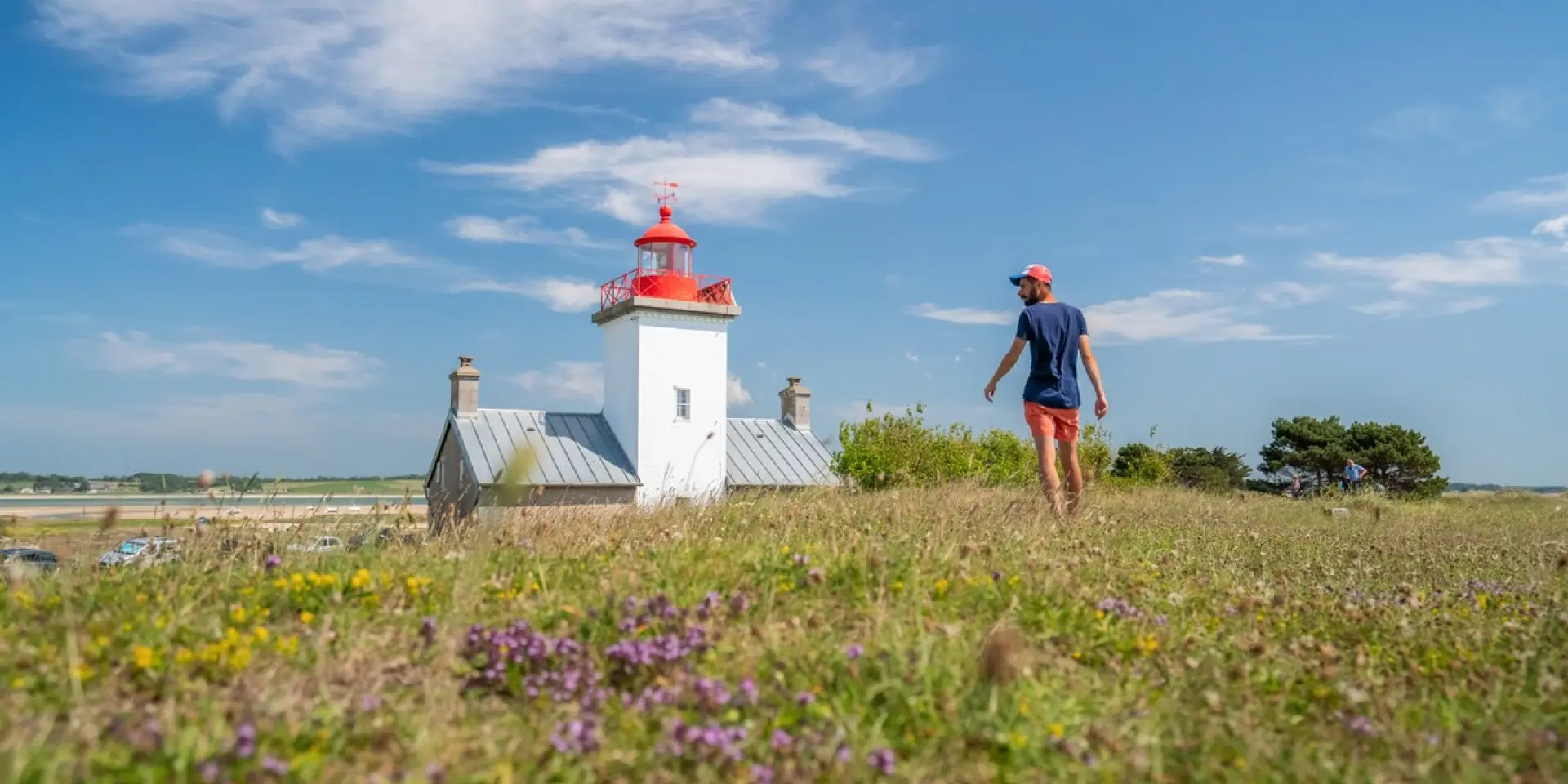 Personne marchant dans un champ de fleurs près du phare de Agon Coutainville
