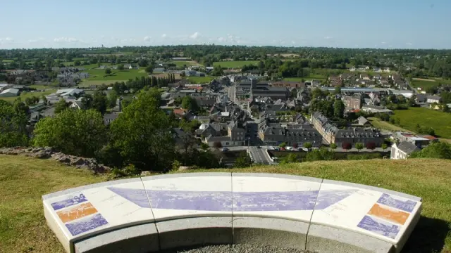 Panoramic view of a town from a hill with a bench in the foreground