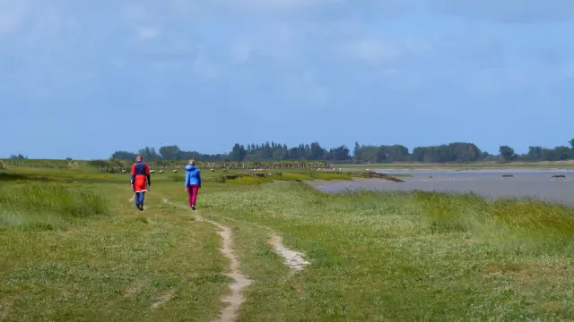Deux personnes marchant sur un chemin de randonnée dans le havre de Regneville