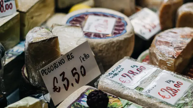 Étal de fromages, terrines et produits artisanaux avec étiquettes de prix
