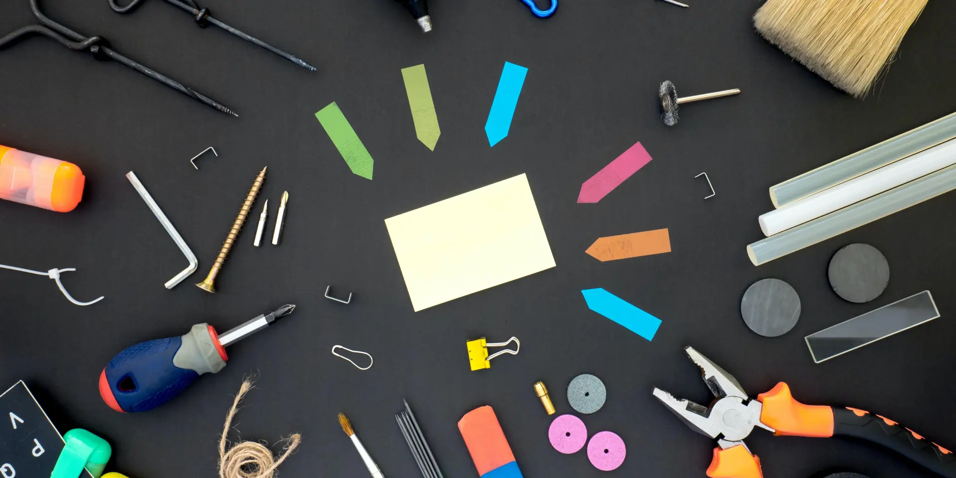 Divers outils et fournitures de bricolage disposés sur une surface noire