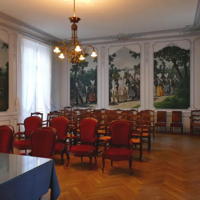 Salle à manger avec des chaises rouges et des peintures murales : salle des mariages de Coutances